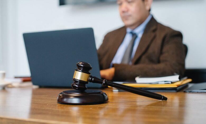 crop asian judge working on laptop in office